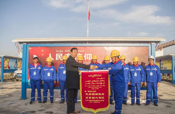 Uyghur employees presented Jia Nengwen with a banner.